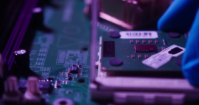 Close-up of installing processor, assembling motherboard in evening, fixing details for gadget in protective blue gloves. Repairing computer components in modern electronic devices laboratory. 