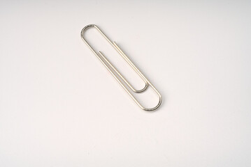 Metal paper clip on white background closeup.