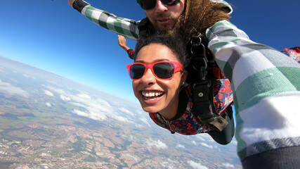 Beautiful black woman practicing skydiving. Tandem jump with selfie image. - 441069669