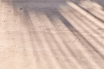 Premium texture with tropical palm leaf shadow on beige natural stone wall. Minimal trendy abstract concrete texture background for cosmetic product presentation. 