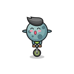Fototapeta premium The cute asteroid character is riding a circus bike