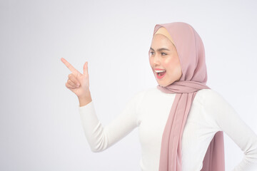 Portrait of young smiling muslim woman wearing a pink hijab over white background studio.