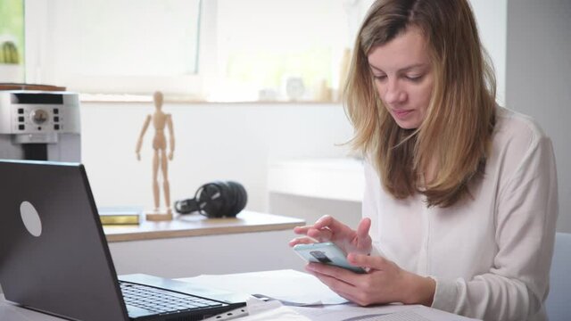 Woman procrastinate ar remote work. Freelancer use smartphone at home office. Unproductive office worker