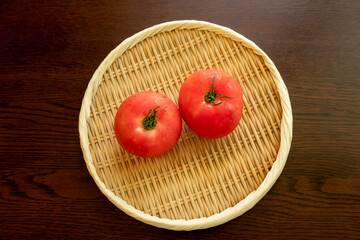円形の竹ザルにのせられた赤いトマト