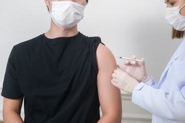 Female doctor injecting covid-19 vaccine to patient arm, covid-19 vaccination and health care concept