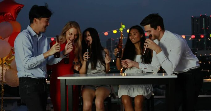 Diverse group, multi-ethnic of businesspeople friends in the office happy and fun in after work party and drinking together on building rooftop.  