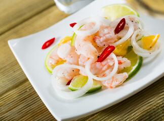 Exotic shrimp ceviche served with sliced lime, mandarine, fresh onion and chili pepper..