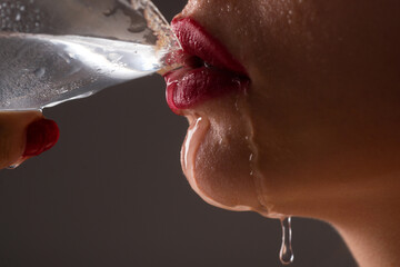 Woman drink water cocktail. Close up wet sexy lips. Young girl drinking red lip cocktail closeup.
