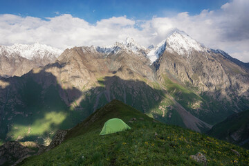 Mountain landscape view in Kyrgyzstan. Rocks, snow and tent in mountain valley view. Mountain panorama.