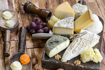 assortiment de fromages Français sur planche et table en bois - obrazy, fototapety, plakaty