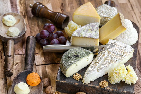 assortiment de fromages Fran&ccedil;ais sur planche et table en bois