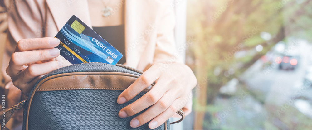 Wall mural woman takes a credit card out of her pocket to make a purchase.