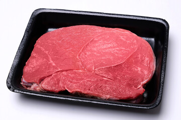 raw fresh beef knuckle steak cut in black tray isolated on white background