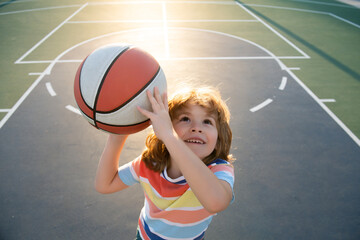 Child boy preparing for basketball shooting. Portrait of sporty kids.