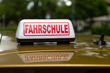 Kennzeichnung eines Fahrschulautos durch ein weis-rotes Hinweisschild  auf dem Dach des Fahrzeuges