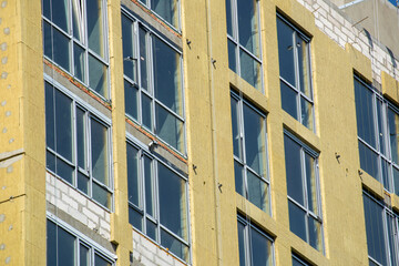 Building external wall thermal insulation with mineral wool. Exterior passive house wall heat insulation with mineral wool. Insulation the facade of commercial building. Energy efficiency