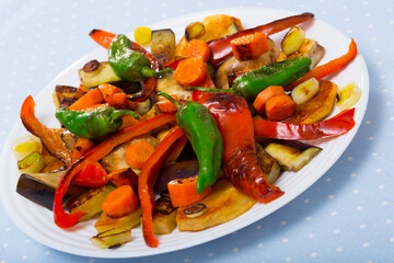 Fototapeta na wymiar Top view of tasty baked vegetables at plate, healthy vegetarian food