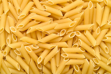 Close-up of uncooked penne pasta. Top view.