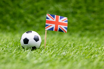 Fototapeta premium Soccer ball with Union Jack Flag are on green grass