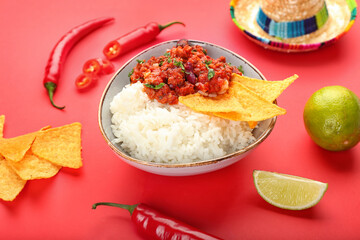 Bowl with tasty chili con carne, rice, nachos, chili pepper and sombrero on color background,...