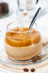milky coffee with cream foam in glass on white background, vertical
