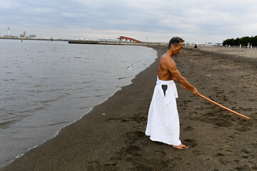 海岸で稽古をする男性　達人イメージ