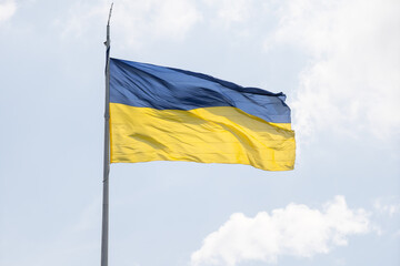 ukranian flag on a pole over beautiful sky