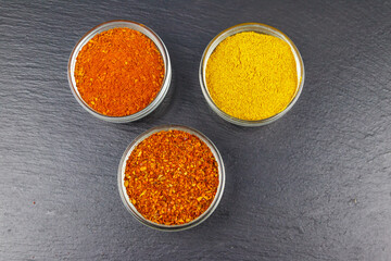 Set of different aromatic spices on black slate. Top view