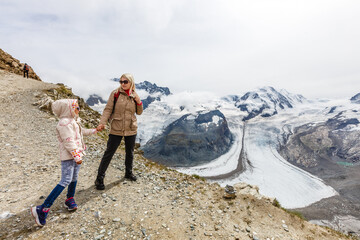 Fototapeta premium Mother and to children going for a walk in mountain surroundings