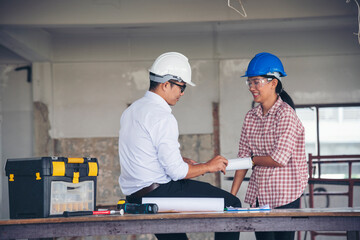 Construction engineer teamwork Safety Suit Trust Team Holding White Yellow Safety hard hat Security Equipment on Construction Site. Hardhat Protect Head for Civil Construction Engineer Concept