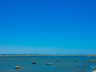 Boats on a small part of the Mediterranean sea protected from the waves by a tongue of land towards Port-Saint- Louis-du-Rh&ocirc;ne in Provence in France