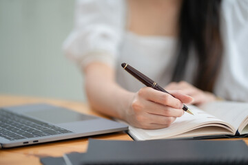 Obraz na płótnie Canvas female hands with pen writing on notebook.