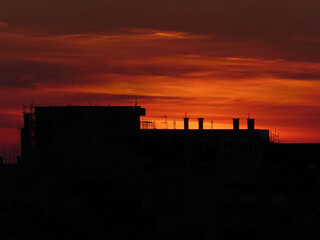 Obraz premium Silhouette of building with chimneys at sunset