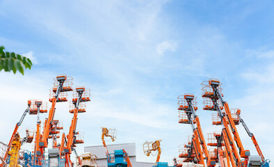 Articulated boom lift. Aerial platform lift. Telescopic boom lift against blue sky. Mobile crane...