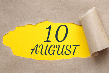 august 10. 10th day of the month, calendar date.Hole in paper with edges torn off. Yellow background is visible through ragged hole.Summer month, day of the year concept