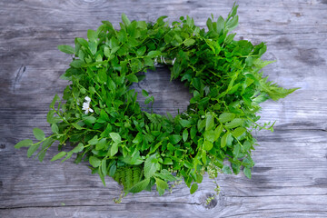Green, flower wreath on gray wooden table