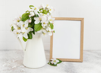 Spring apple blossom in a vase with an empty photo frame
