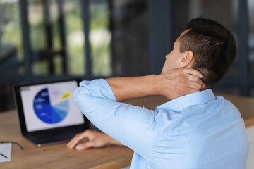 Young caucasian businessman feeling severe having neck pain from a long sedentary work at the...