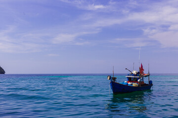 Fototapeta na wymiar fishing boat on the sea near island with blue sky on sunny day