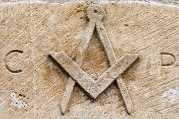 Symbole maçonnique (équerre et compas) sur un linteau en pierre à Vuillafans, Doubs,...