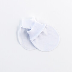 White mittens for newborns, top view. We're expecting a baby. It's time to give birth, it's time to go to the maternity hospital. Concept: fashion for newborns, a variety of colorful clothes.
