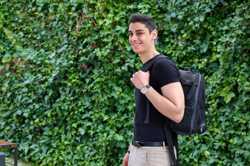 Naklejka na ściany i meble University student standing outside with backpack smiling