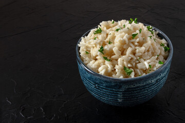 A bowl of white rice on a black background with a place for text