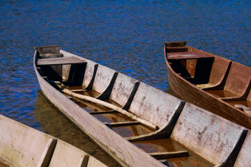traditional wooden flat-bottomed boats on the river bank, rural landscape