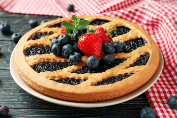 Delicious blueberry pie on rustic wooden background with kitchen towel
