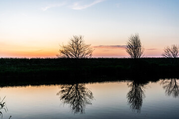Obraz premium Sunset with reflection in the water in the Netherlands