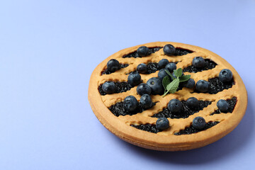 Delicious blueberry pie with berries on violet background
