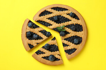 Delicious blueberry pie with berries on yellow background