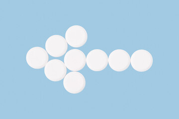 White pills isolated on blue background. Medical concept.