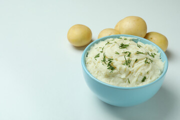 Plate of mashed potatoes and ingredients on white background
